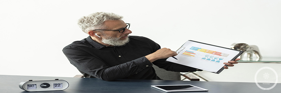 older-man-home-showing-graph-notepad-with-tablet-desk older-man-home-showing-graph-notepad-with-tablet-desk