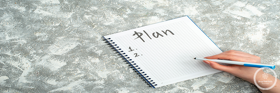 Overhead view of hand writing on spiral notebook on gray backgro Overhead view of hand writing on spiral notebook on gray background